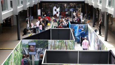 Vue du labyrinthe des Deep Fakes, dans l'Atrium BC: plusieurs panneaux disposés de manière à faire un parcours. Dans ce labyrinthe, plusieurs écrans avec des visages. © Alain Herzog / EPFL 2022